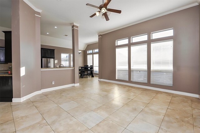 tiled empty room featuring lofted ceiling, crown molding, ceiling fan, and ornate columns