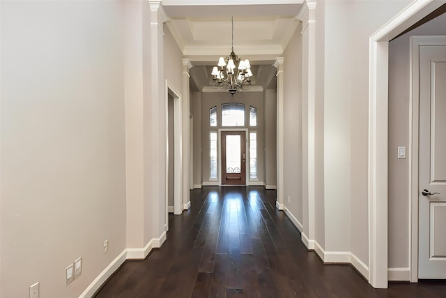 entryway with ornamental molding, dark wood-style floors, baseboards, and a chandelier