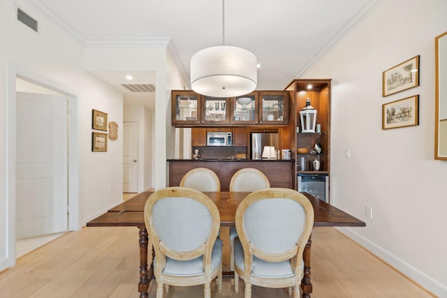 dining room with crown molding and light wood-type flooring