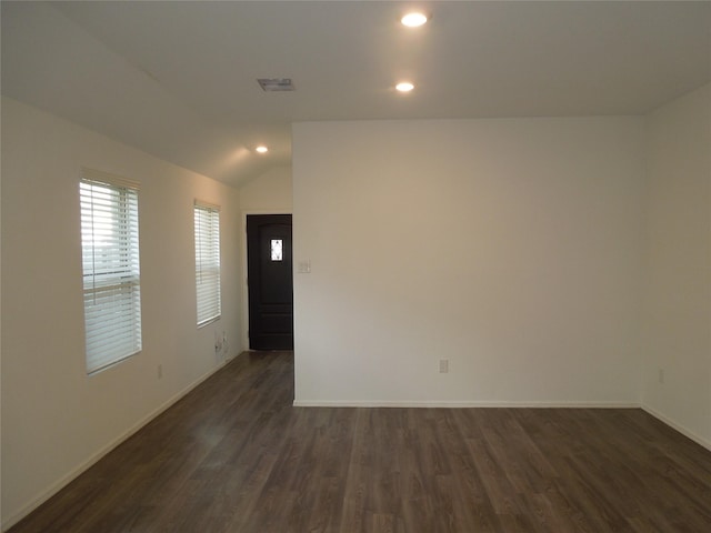 empty room featuring vaulted ceiling and dark hardwood / wood-style floors