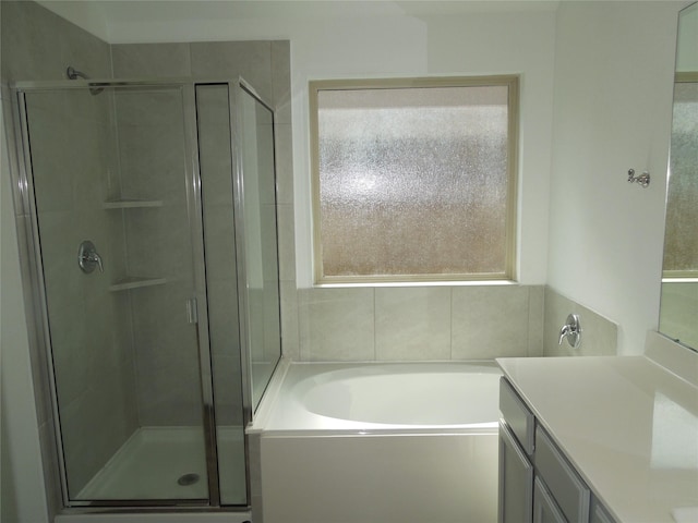 bathroom featuring a shower stall, a garden tub, and vanity