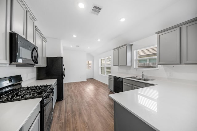 18415 Running Shadow Ct, Hockley, TX 77447 - kitchen featuring black appliances, gray cabinets, light countertops, lofted ceiling, and a sink