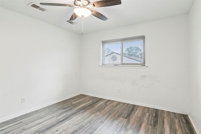 spare room featuring dark wood-type flooring, ceiling fan, and a textured ceiling