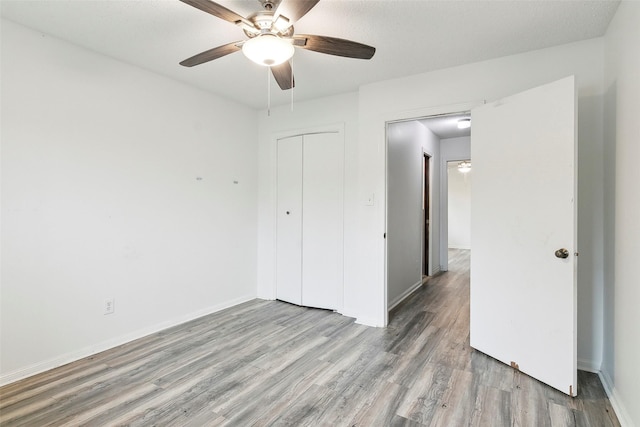 unfurnished bedroom featuring a closet, ceiling fan, and light wood-type flooring