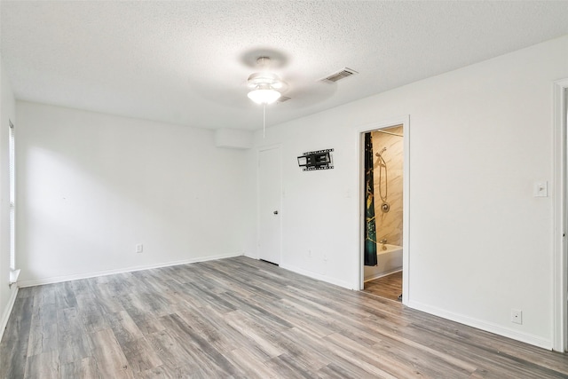 unfurnished room featuring ceiling fan, wood-type flooring, and a textured ceiling