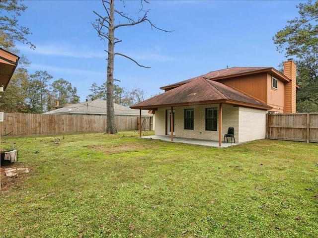 rear view of house with a patio and a lawn