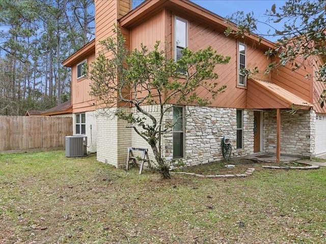 back of property featuring a garage, a yard, and central AC