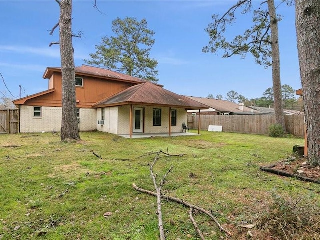 back of house featuring a lawn and a patio