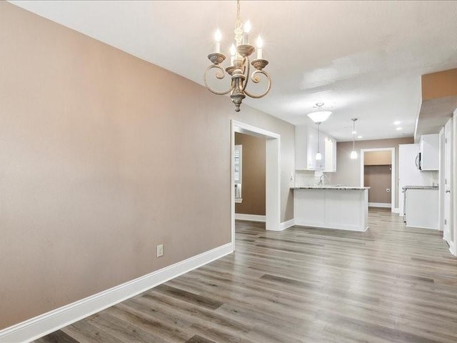 unfurnished living room featuring dark hardwood / wood-style flooring and a notable chandelier