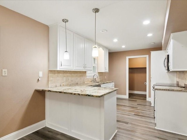 kitchen featuring pendant lighting, white cabinetry, light stone counters, tasteful backsplash, and kitchen peninsula