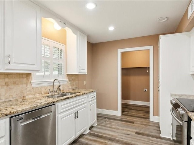 kitchen with light stone counters, sink, white cabinets, and appliances with stainless steel finishes