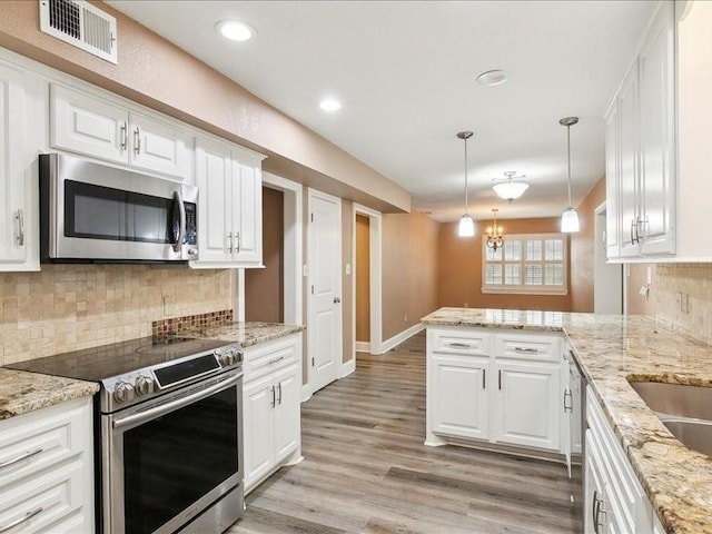 kitchen with white cabinetry, stainless steel appliances, kitchen peninsula, and decorative backsplash