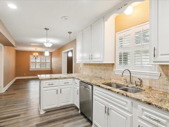 kitchen featuring sink, white cabinetry, decorative light fixtures, stainless steel dishwasher, and kitchen peninsula