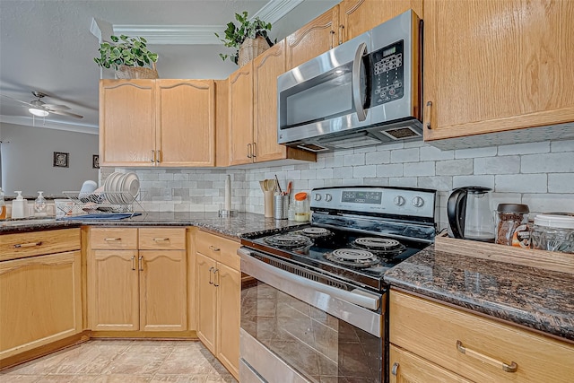 kitchen with light brown cabinetry, tasteful backsplash, dark stone countertops, stainless steel appliances, and crown molding