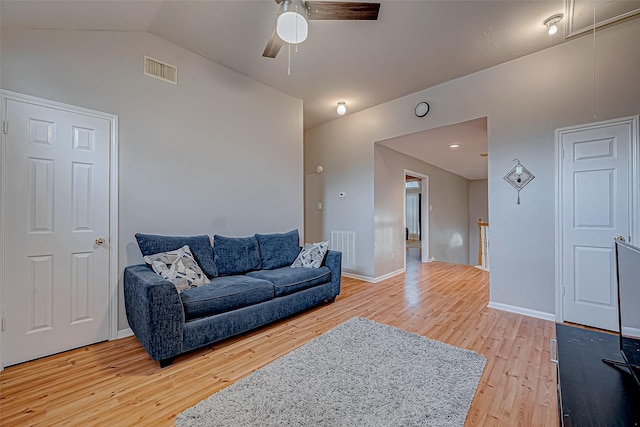 living room with ceiling fan, vaulted ceiling, and light wood-type flooring