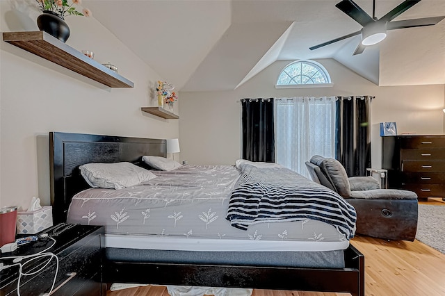 bedroom with hardwood / wood-style flooring, vaulted ceiling, and ceiling fan