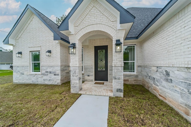 view of exterior entry with a lawn