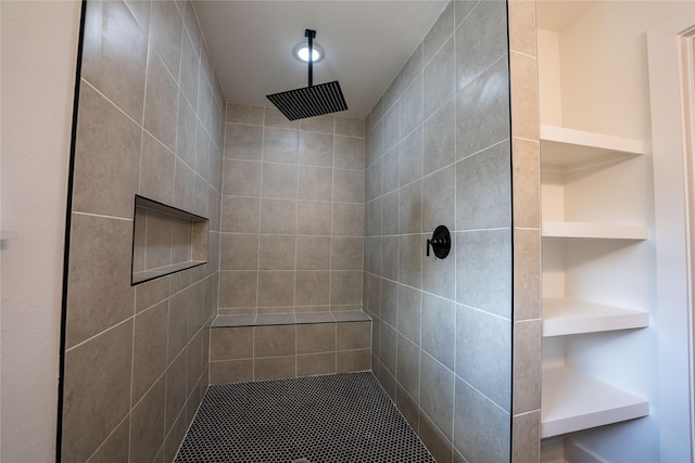 bathroom featuring a tile shower and built in features