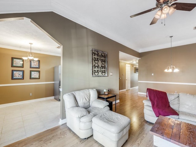 living room with ornamental molding, lofted ceiling, ceiling fan with notable chandelier, and light hardwood / wood-style flooring