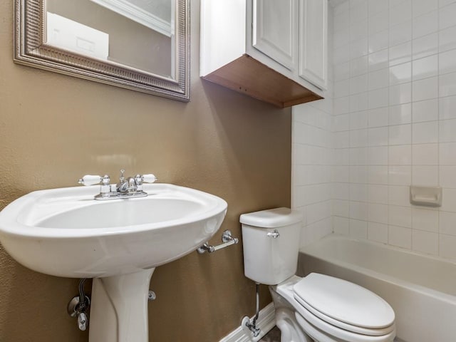 bathroom with tiled shower / bath combo and toilet