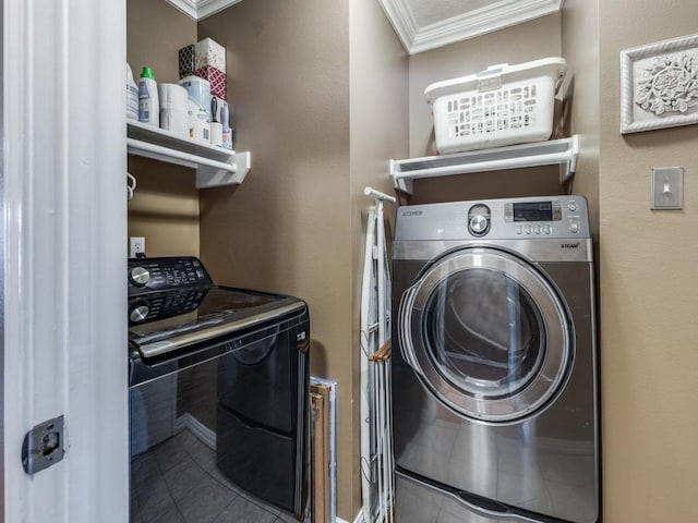 laundry area featuring ornamental molding, tile patterned floors, and washing machine and dryer