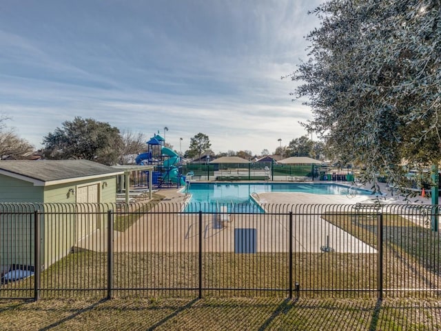 view of swimming pool with a playground, a water slide, a yard, and a patio area