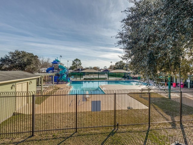 view of swimming pool with a playground and a yard