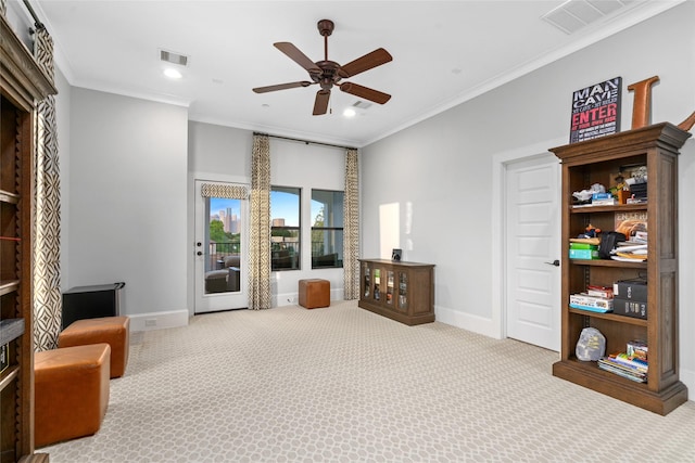 sitting room with ceiling fan, light colored carpet, and ornamental molding