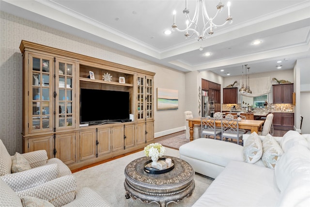 living room featuring crown molding, a chandelier, and light hardwood / wood-style floors