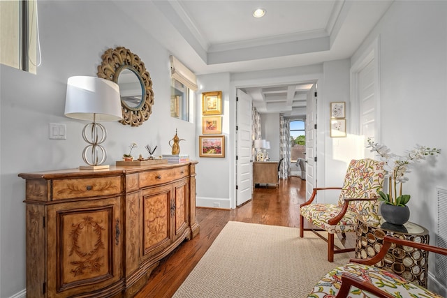 interior space featuring wood-type flooring, ornamental molding, and a raised ceiling