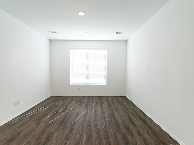 unfurnished room with dark wood-type flooring