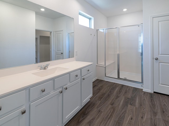 bathroom with wood-type flooring, an enclosed shower, and vanity