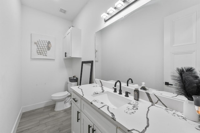 bathroom featuring vanity, hardwood / wood-style floors, and toilet