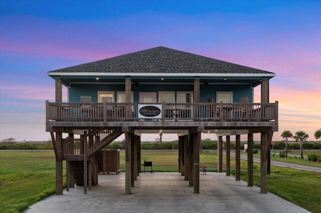 view of front facade featuring a lawn, a carport, and covered porch