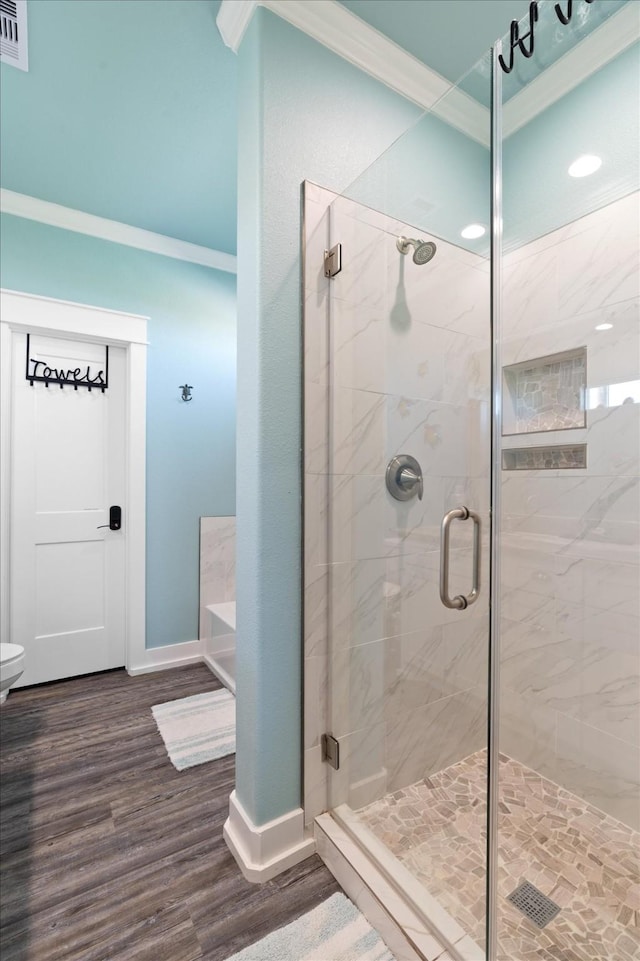 bathroom with ornamental molding, shower with separate bathtub, and hardwood / wood-style floors