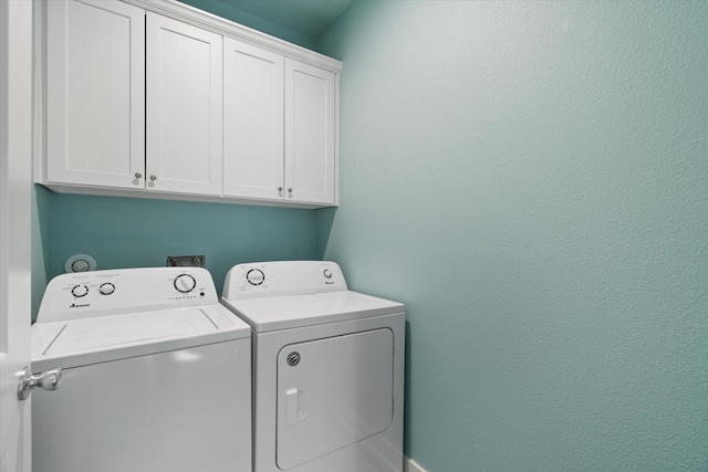 laundry room with washing machine and dryer and cabinets