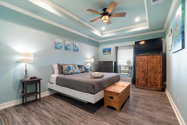 bedroom featuring dark wood-type flooring, ceiling fan, crown molding, and a raised ceiling