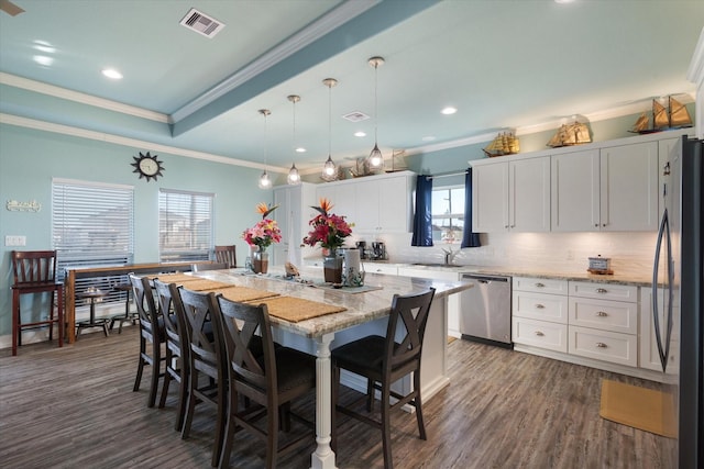 kitchen featuring dark wood-type flooring, decorative light fixtures, a center island, black appliances, and white cabinets