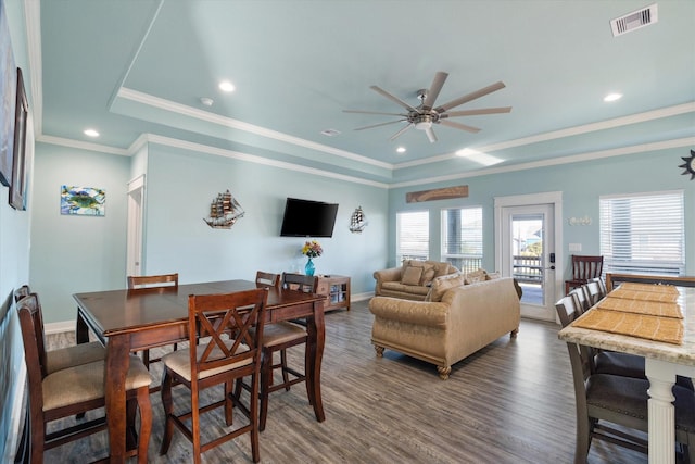 dining area featuring crown molding, ceiling fan, dark hardwood / wood-style flooring, and a tray ceiling