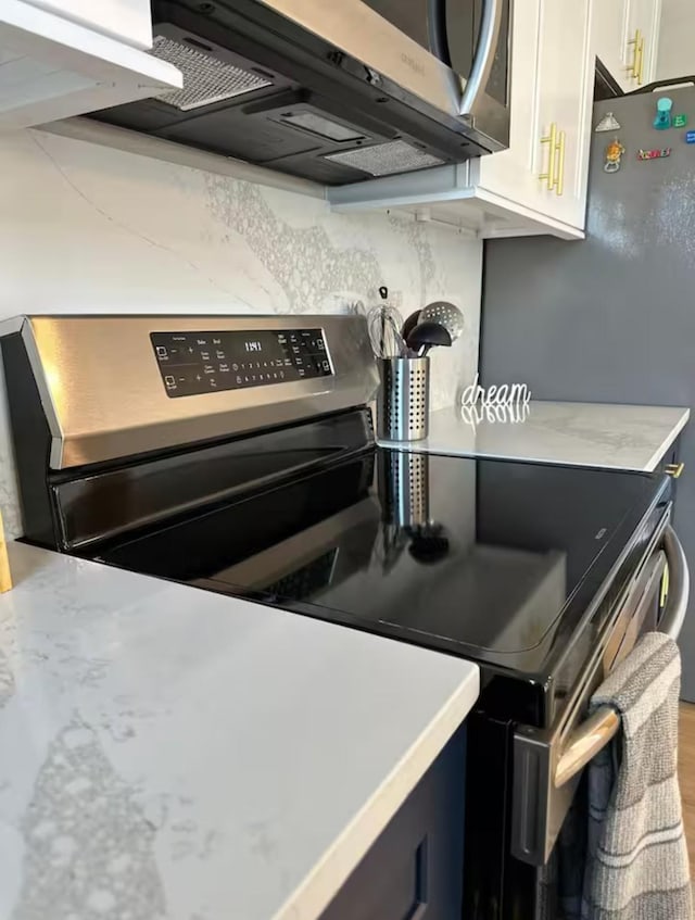 kitchen with tasteful backsplash, appliances with stainless steel finishes, and white cabinets