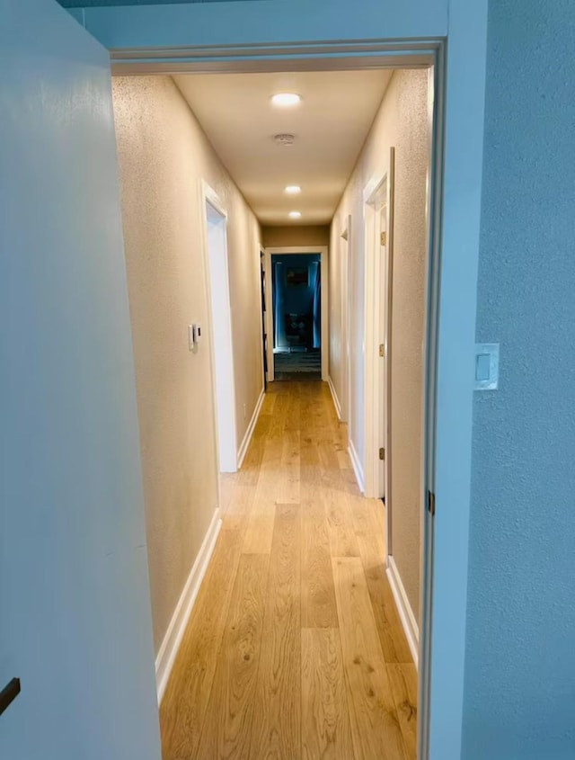 corridor with light hardwood / wood-style flooring