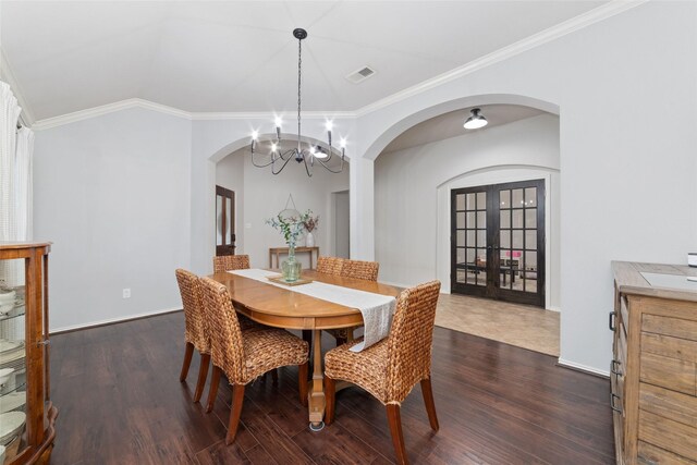 dining area with crown molding, dark hardwood / wood-style floors, a chandelier, and french doors