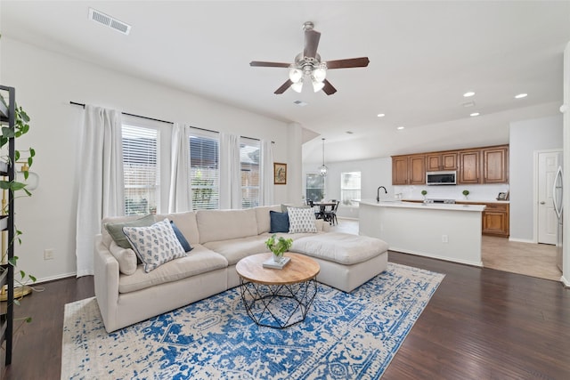 living room featuring ceiling fan, wood-type flooring, and sink