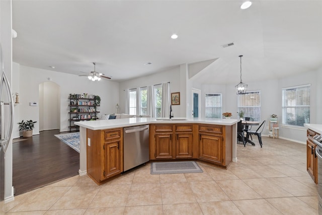 kitchen with light tile patterned flooring, ceiling fan with notable chandelier, decorative light fixtures, sink, and stainless steel dishwasher