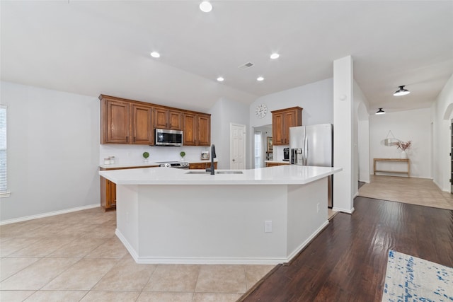 kitchen featuring light tile patterned flooring, sink, a center island with sink, appliances with stainless steel finishes, and plenty of natural light