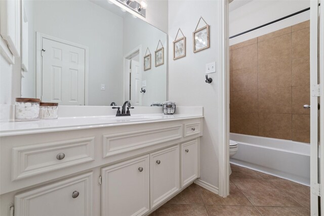 full bathroom featuring tiled shower / bath, tile patterned floors, toilet, and vanity