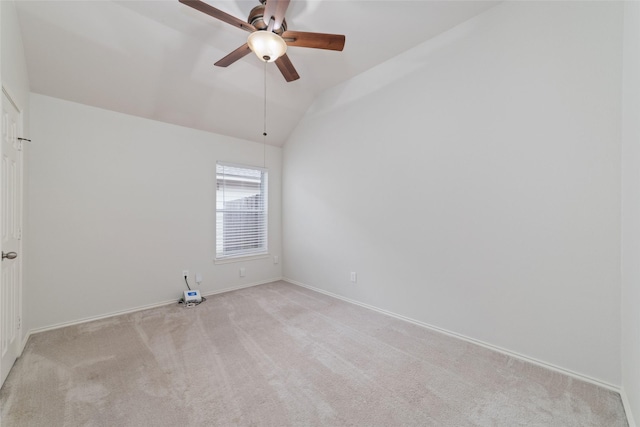 spare room with vaulted ceiling, light colored carpet, and ceiling fan