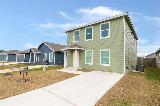 view of front of house with a front lawn and central air condition unit