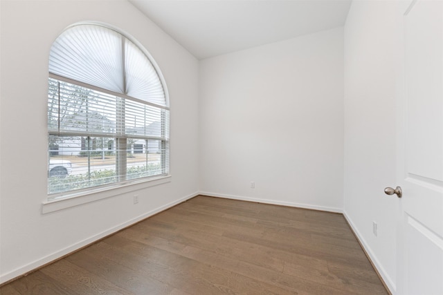 unfurnished room with baseboards and wood finished floors