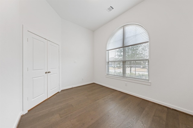 unfurnished room with wood finished floors, visible vents, and baseboards